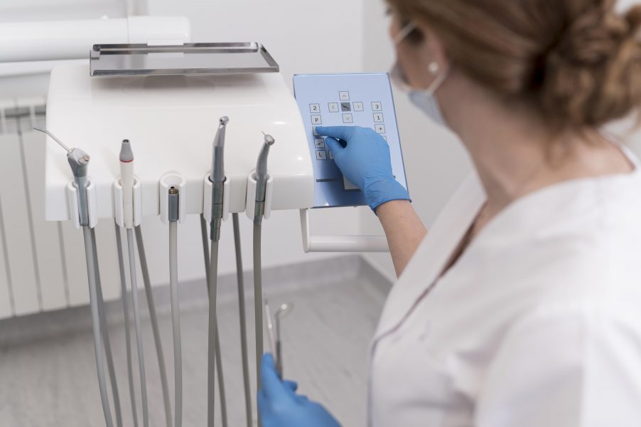 female-orthodontist-with-latex-gloves-handling-dental-equipment