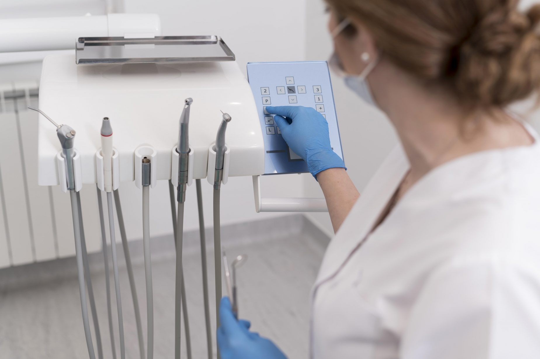 female-orthodontist-with-latex-gloves-handling-dental-equipment