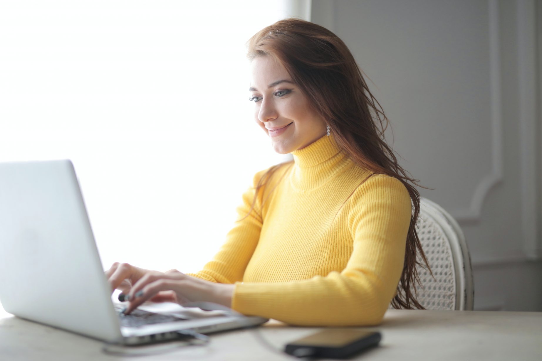 woman-in-yellow-turtleneck-sweater-using-laptop-3884186